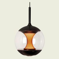 Clear glass globe pendant with amber glow core on a cream background