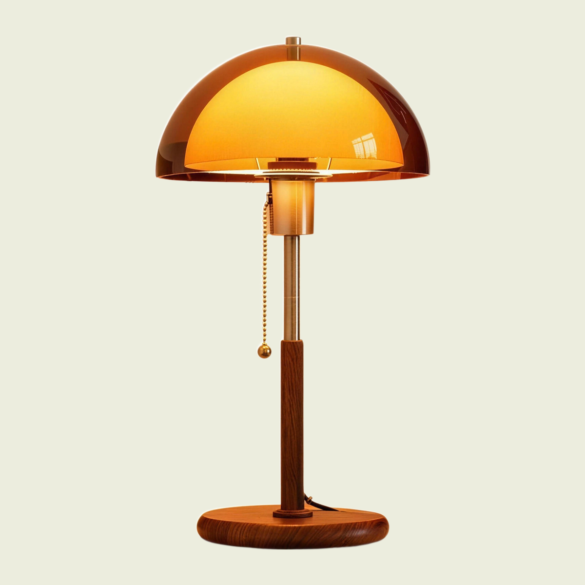 Amber dome table lamp with walnut base and brass pull chain, switched on, front view