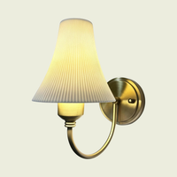 Brass pleated ceramic wall sconce, front view