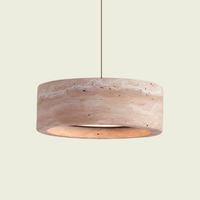 Cylinder travertine drum pendant light with glowing open ring, front view