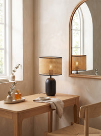Woven Cane-Style Drum Table Lamp lit on a dressing table in daylight