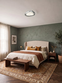 Organic chrome triangle ceiling light on the ceiling of a daylit sage green bedroom