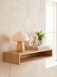 Ceramic Mushroom Table Lamp glowing on a wall shelf in a daylit nursery
