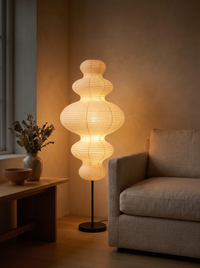 Paper gourd floor lamp glowing like a lantern in a dark living room at night