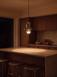 Chrome Bell Pendant Light as the only light over a kitchen island at night