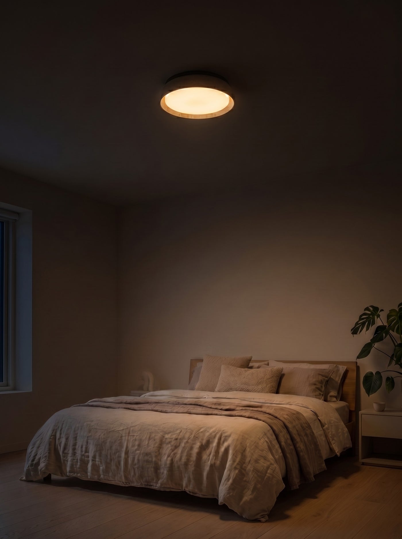 Wood frame ceiling light glowing over a bed at night