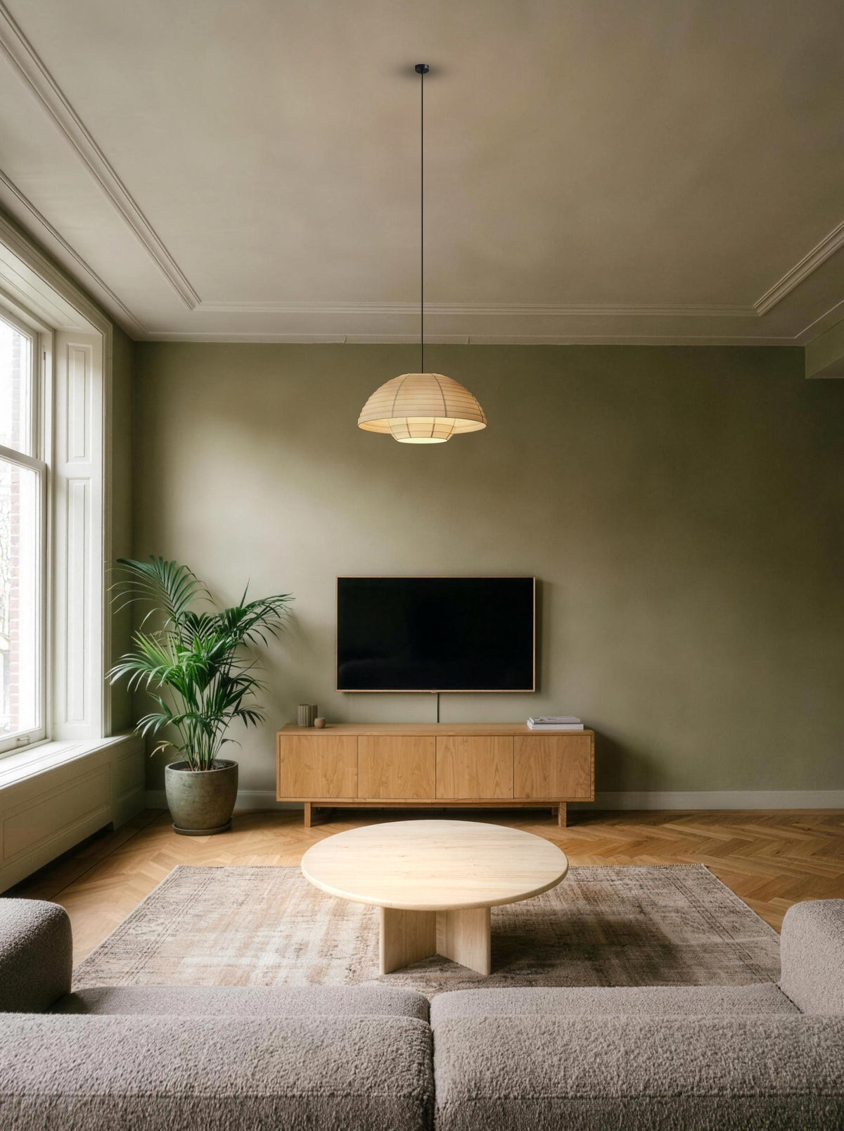 Woven dome pendant light over the coffee table in a daylit olive green living room