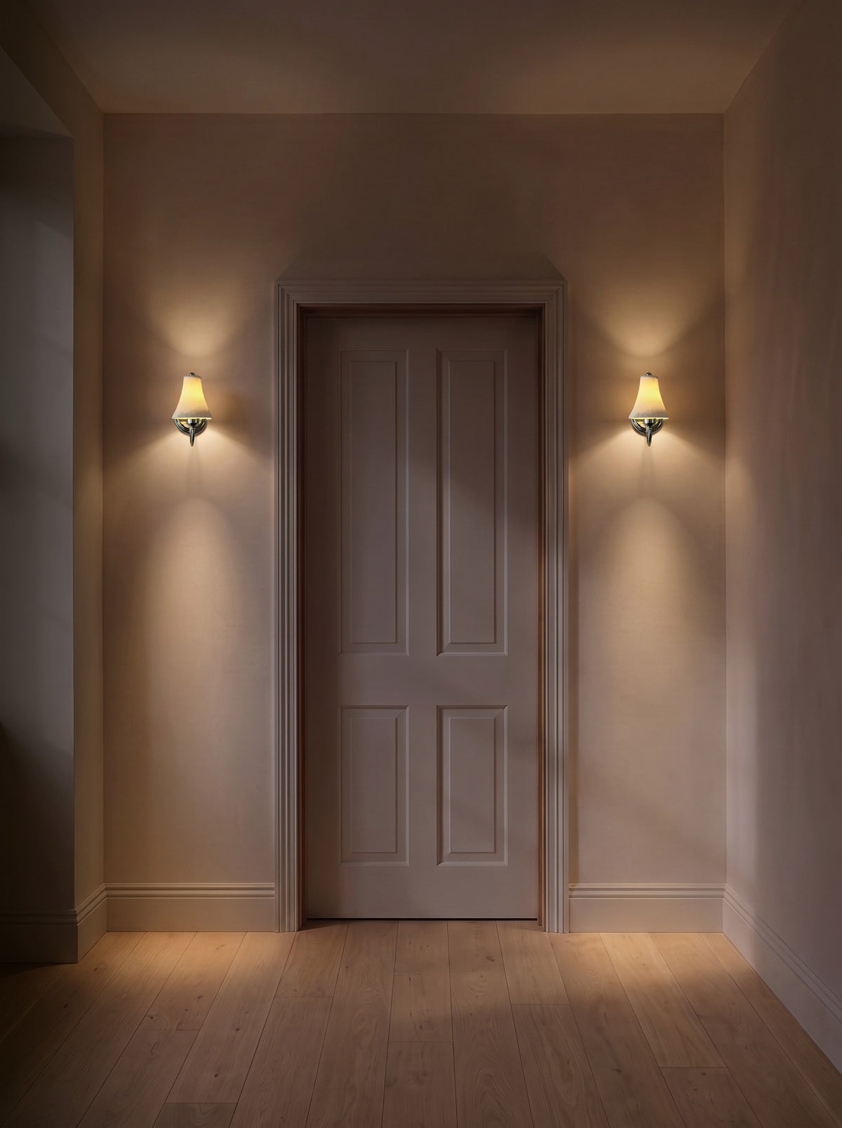 A pair of chrome pleated ceramic wall sconces as the only light in a dark hallway at night
