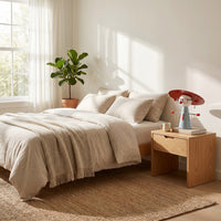 Cordless bedside lamp on a nightstand in daylight, holding glasses and jewelry on its arms