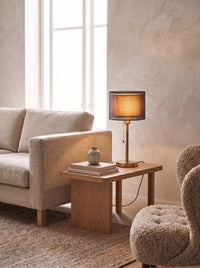 Double Shade Bedside Lamp lit on a living room side table in daylight