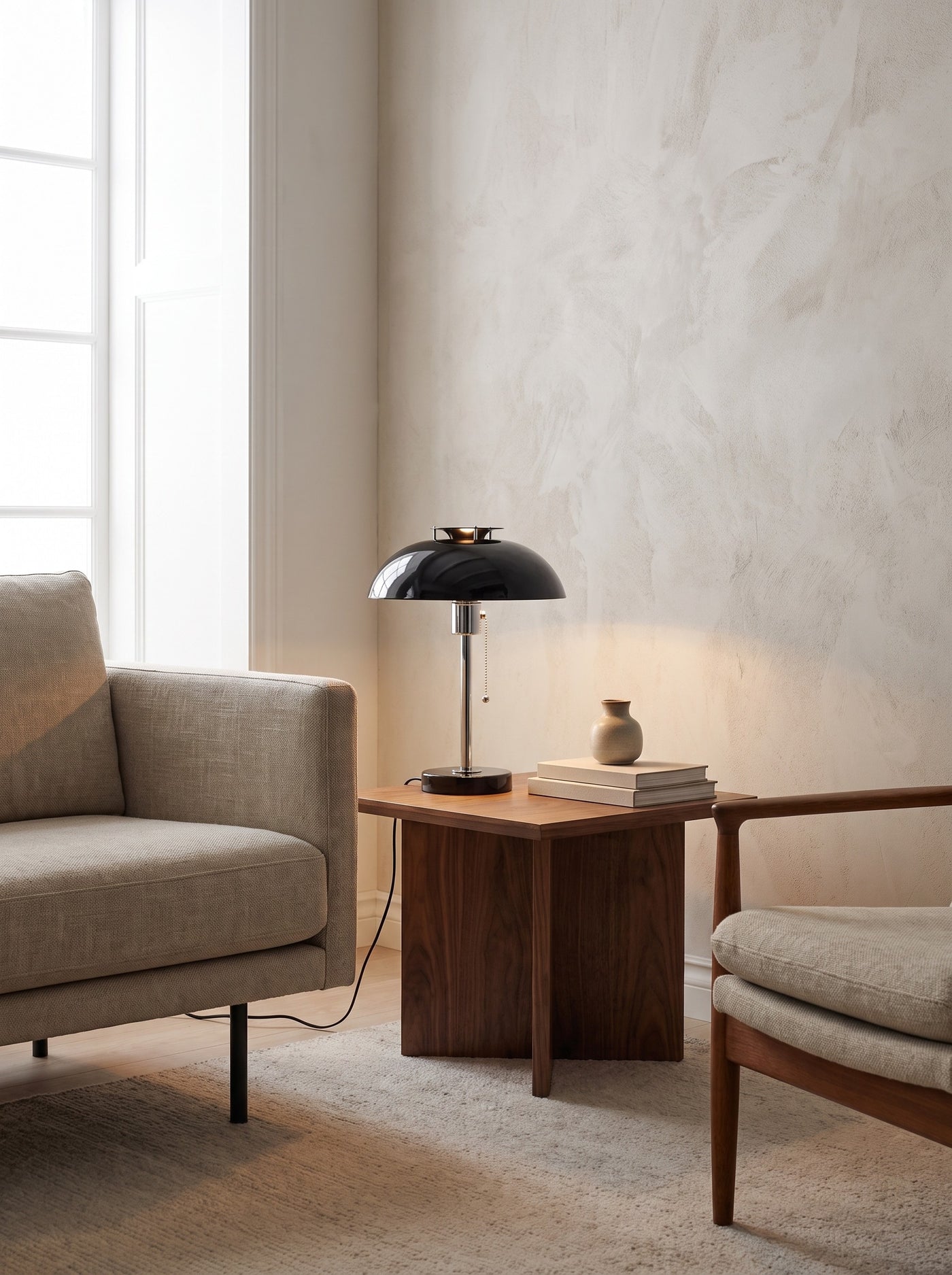 Domed Metal Table Lamp in black lit on a living room side table in daylight