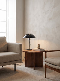 Domed Metal Table Lamp in black lit on a living room side table in daylight