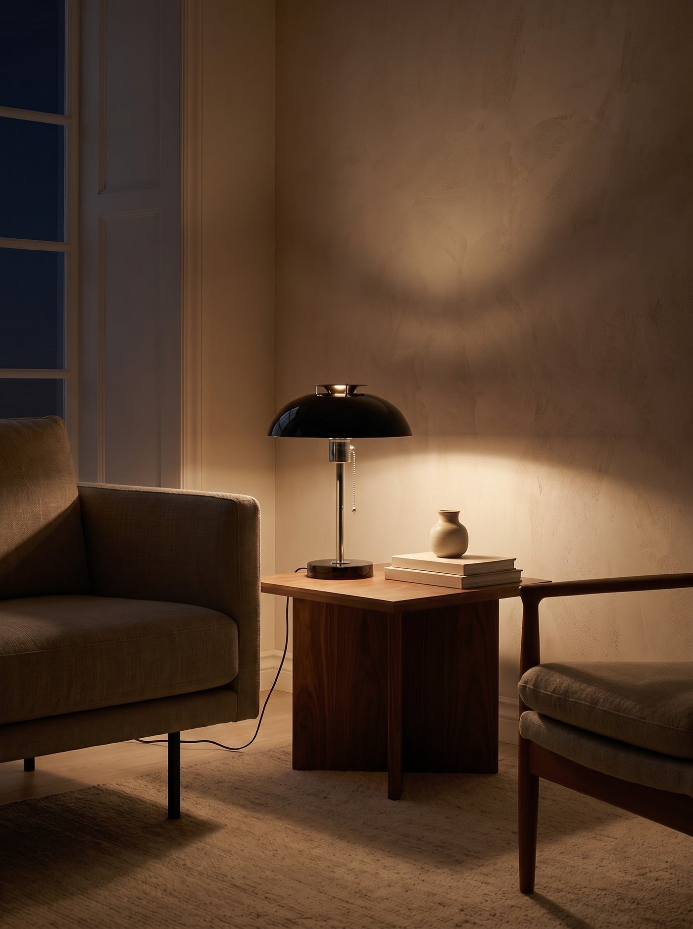 Domed Metal Table Lamp as the only light at night beside an armchair