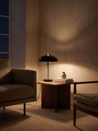 Domed Metal Table Lamp as the only light at night beside an armchair