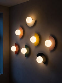 Iron half moon wall sconces glowing warm on a wall in a dark room at night