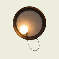 Black fabric disc wall sconce with opal glass globe and grey felt shade, front view