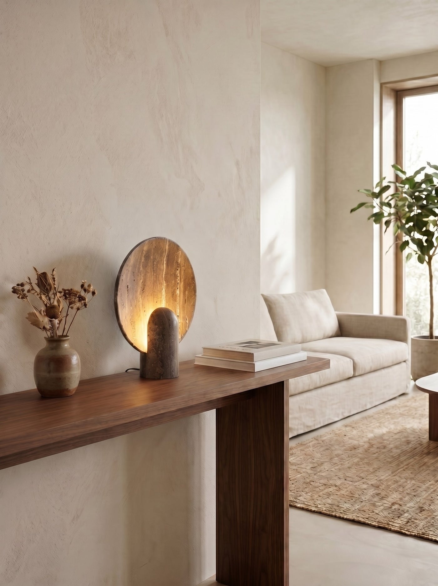 Travertine disc table lamp on a walnut console in a daytime living room