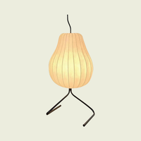 Silk pear floor lamp, pleated shade on a black wire tripod, on a cream background