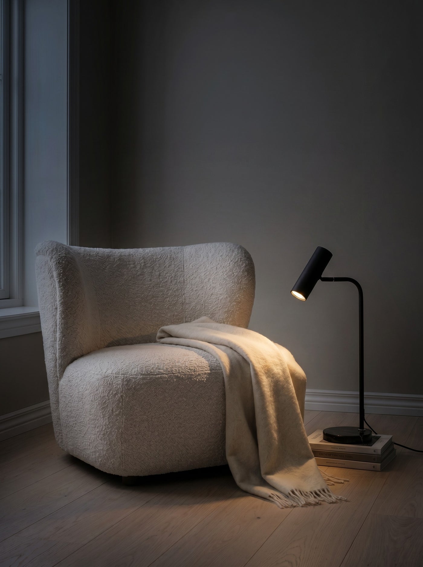 Black spotlight floor lamp casting a warm reading pool at night