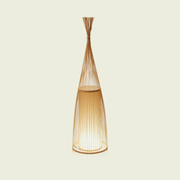 Woven bamboo floor lamp on a cream background