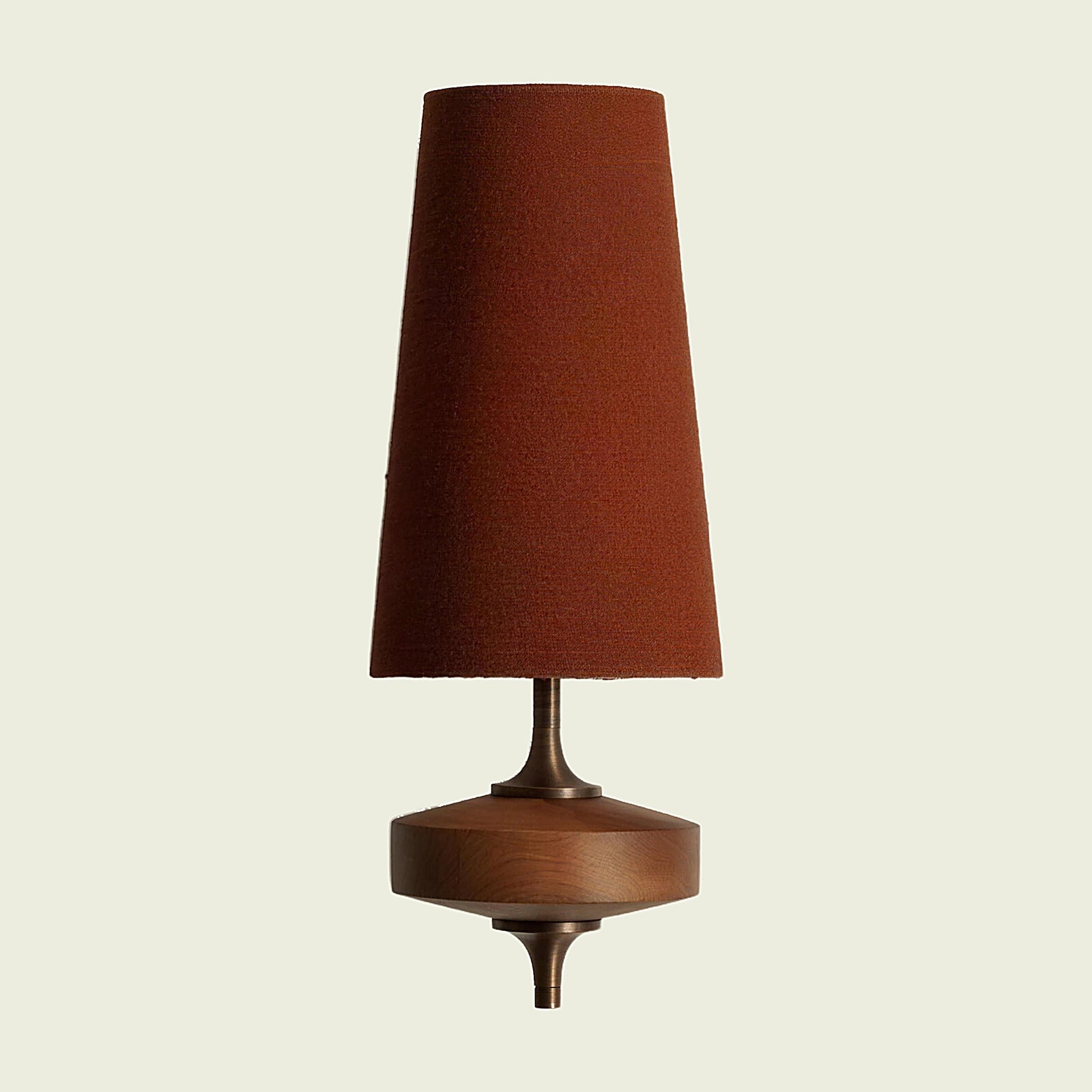 Red fabric cone wall sconce on a turned walnut mount, front view