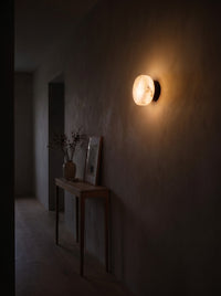 Marble dome wall sconce glowing in a hallway at night