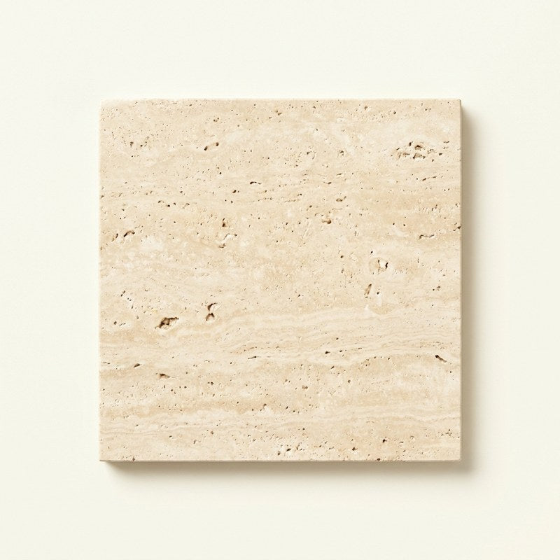 Polished travertine stone sample with natural pores and soft banding
